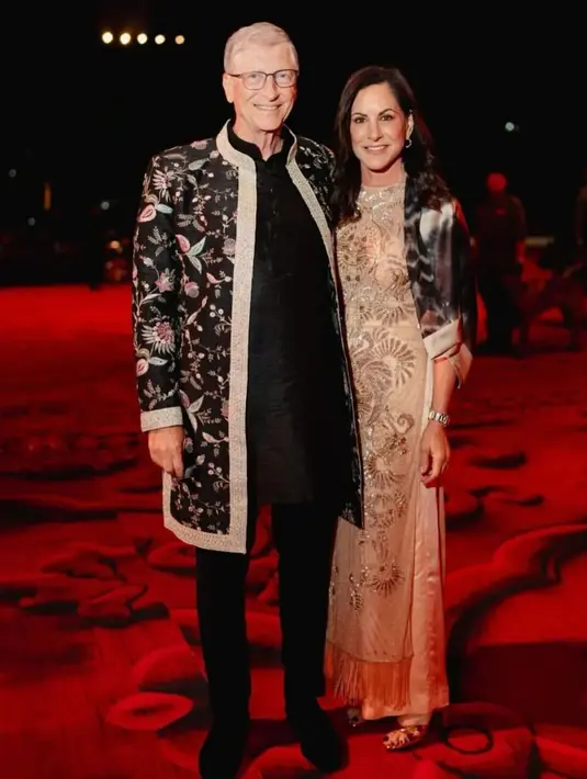 Bill Gates tampil mengenakan Lungi, baju India untuk pria. Lungi pilihan Bill Gates memiliki corak floral, melapisi inner hitam, yang dipadukannya dengan celana panjang hitam. [Foto: Instagram/asianweddingmag]