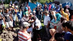 Kerumunan warga menonton pemindahkan jasad dari kuburan di Desa Toto Selatan, Kabupaten Bone Bolango, Gorontalo, Sabtu (12/1). Pemilik lahan tak terima lantaran keluarga jenazah menolak ajakan untuk memilih salah satu caleg. (Liputan6.com/Arfandi Ibrahim)