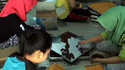 Sejumlah pekerja membuat kue kering di industri rumahan yang berada di kawasan Sidamukti, Depok, Jawa Barat, Senin (4/6). Pedagang menjual kue kering dengan harga mulai dari Rp 32.000-Rp 36.000 per toples. (Merdeka.com/Arie Basuki)