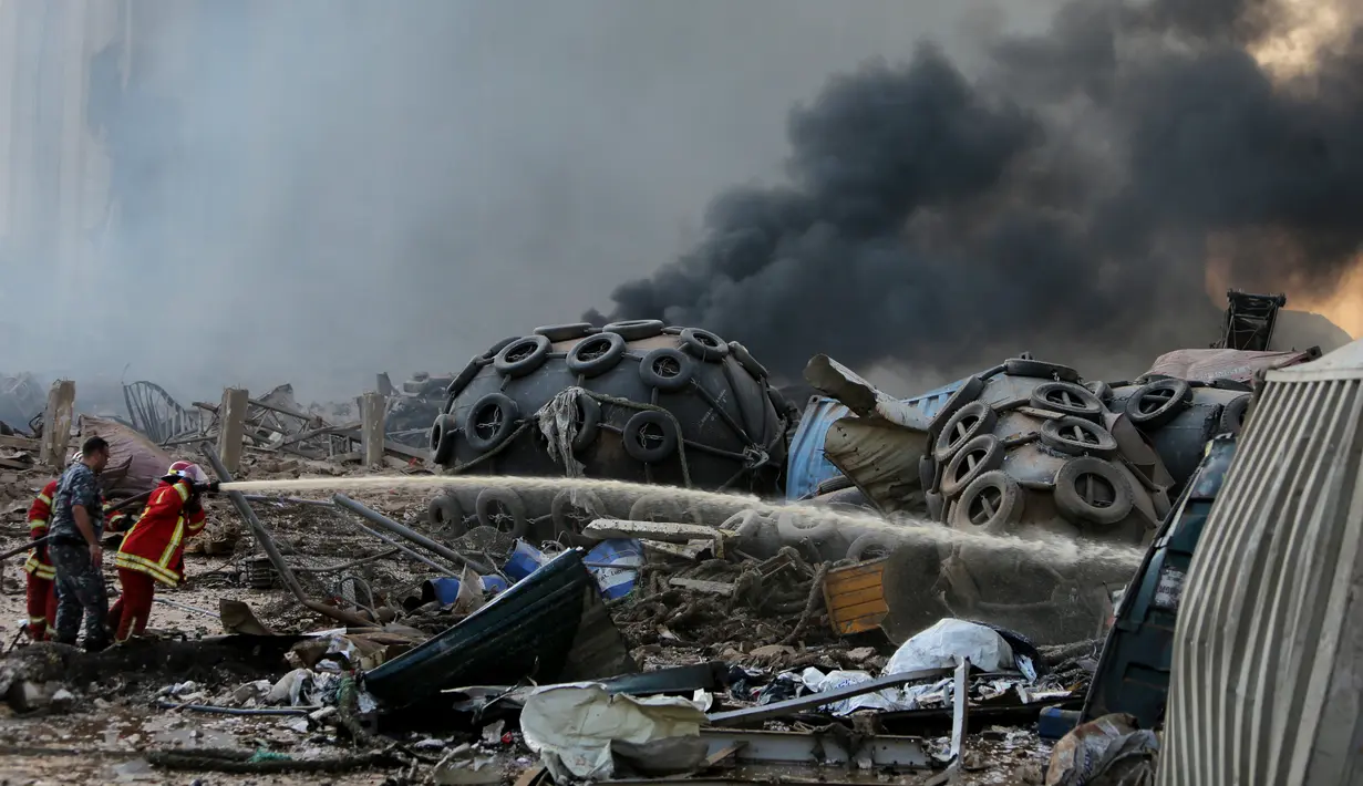 Petugas memadamkan api setelah ledakan besar di Beirut, Lebanon, Selasa, (4/8/2020). Dua ledakan besar mengguncang ibukota Lebanon, Beirut, melukai puluhan orang, menghancurkan gedung-gedung dan mengirimkan asap besar mengepul ke langit. (AFP/STR)