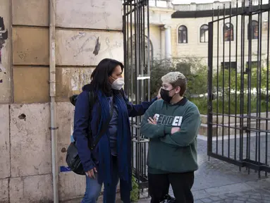 Matteo Coccimiglio berbicara dengan seorang guru, Sonia Mugello di Sekolah Seni Ripetta di Roma, Italia, 24 Maret 2021. Siswa 18 tahun itu mengidentifikasi dirinya sebagai laki-laki, dan sedang dalam proses mengubah status gendernya dari perempuan menjadi pria. (AP Photo/Alessandra Tarantino)