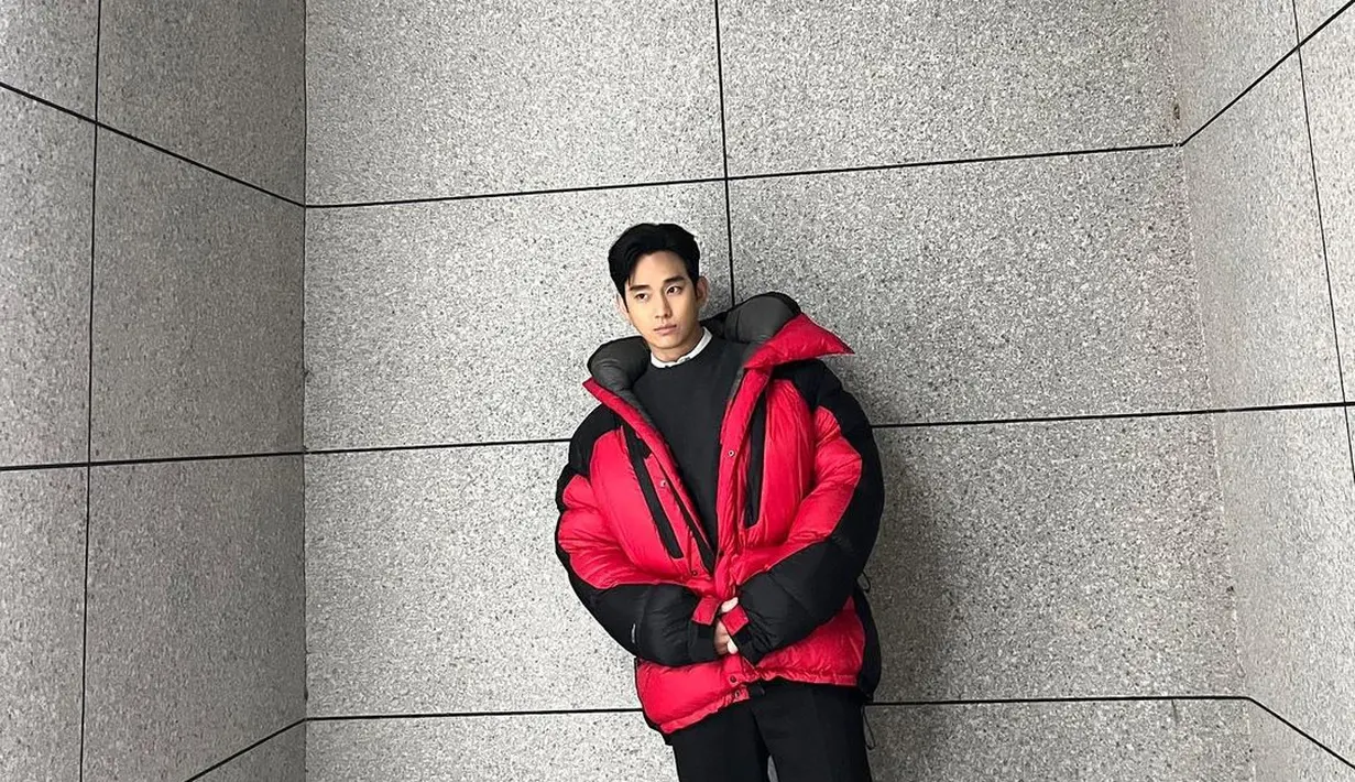 Kim Soo Hyun memperlihatkan tubuhnya yang tinggi menjulang lewat padu padan outfit ini. Ia madukan kemeja putih yang ditumpuknya dengan sweater hitam, lalu puffer jacket merah, dan celana panjang hitam. [Foto: Instagram/soohyun_k216]