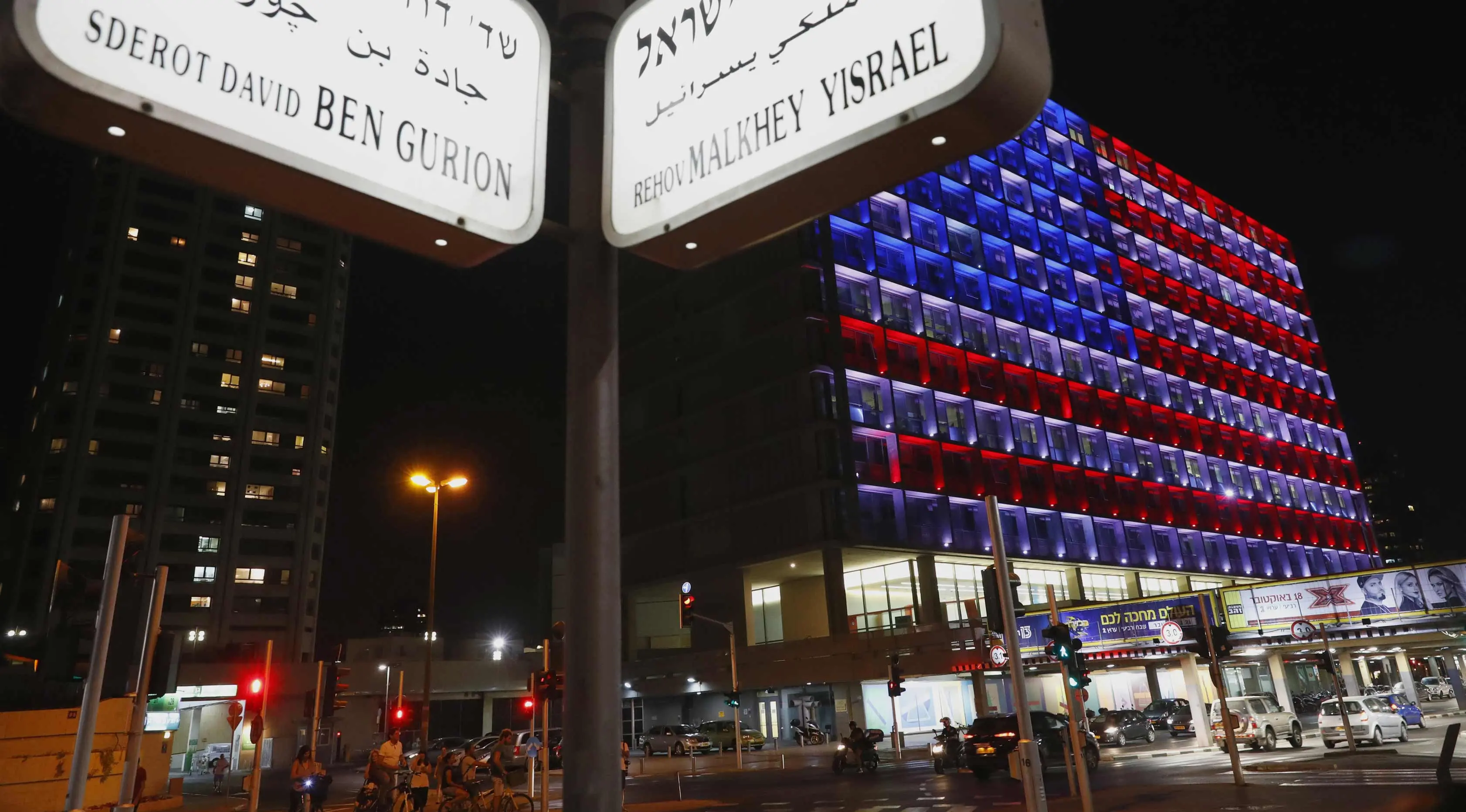 Suasana di dekat balai kota Tel Aviv yang dihiasi warna bendera AS untuk menghormati korban penembakan brutal di Las Vegas di Rabin Square, Tel Aviv (2/10). Menurut laporan, pelaku Stephen Paddock bunuh diri di lokasi kejadian. (AFP Photo/Jack Guez)