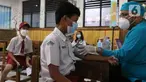 Petugas menyuntikan vaksin COVID-19 Pfizer kepada seorang siswa di SDN Panunggangan 5, Pinang, Kota Tangerang, Selasa (19/10/2021).  Pelaksanaan vaksinasi untuk pelajar usia 12 tahun ini dilakukan dalam rangka persiapan pelaksanaan pembelajaran tatap muka (PTM). (Liputan6.com/Angga Yuniar)