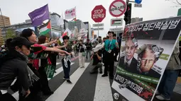 Warga yang menyatakan solidaritas terhadap Palestina melempar sepatu ke arah papan bergambar Presiden Amerika Serikat Donald Trump dan Perdana Menteri Israel Benjamin Netanyahu saat berjalan menuju Kedutaan Besar AS dalam aksi yang mengecam tindakan militer AS dan Israel di Gaza, di Seoul, Korea Selatan, Sabtu (3/10/2026). Aksi tersebut merupakan bagian dari rangkaian unjuk rasa yang menyuarakan dukungan terhadap Palestina dan menyerukan penghentian konflik di Gaza. (AP Photo/Ahn Young-joon)