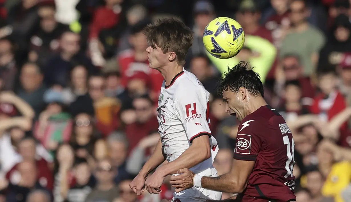 Gelandang AC Milan, Charles De Ketelaere dan pemain Salernitana, Ivan Radovanovic bertarung memperebutkan bola selama pertandingan lanjutan Liga Serie A Italia di stadion Arechi di Salerno, Italia, Rabu (4/1/2023). AC Milan menang tipis atas Salernitana  dengan skor 2-1. (Alessandro Garofalo/LaPresse via AP)