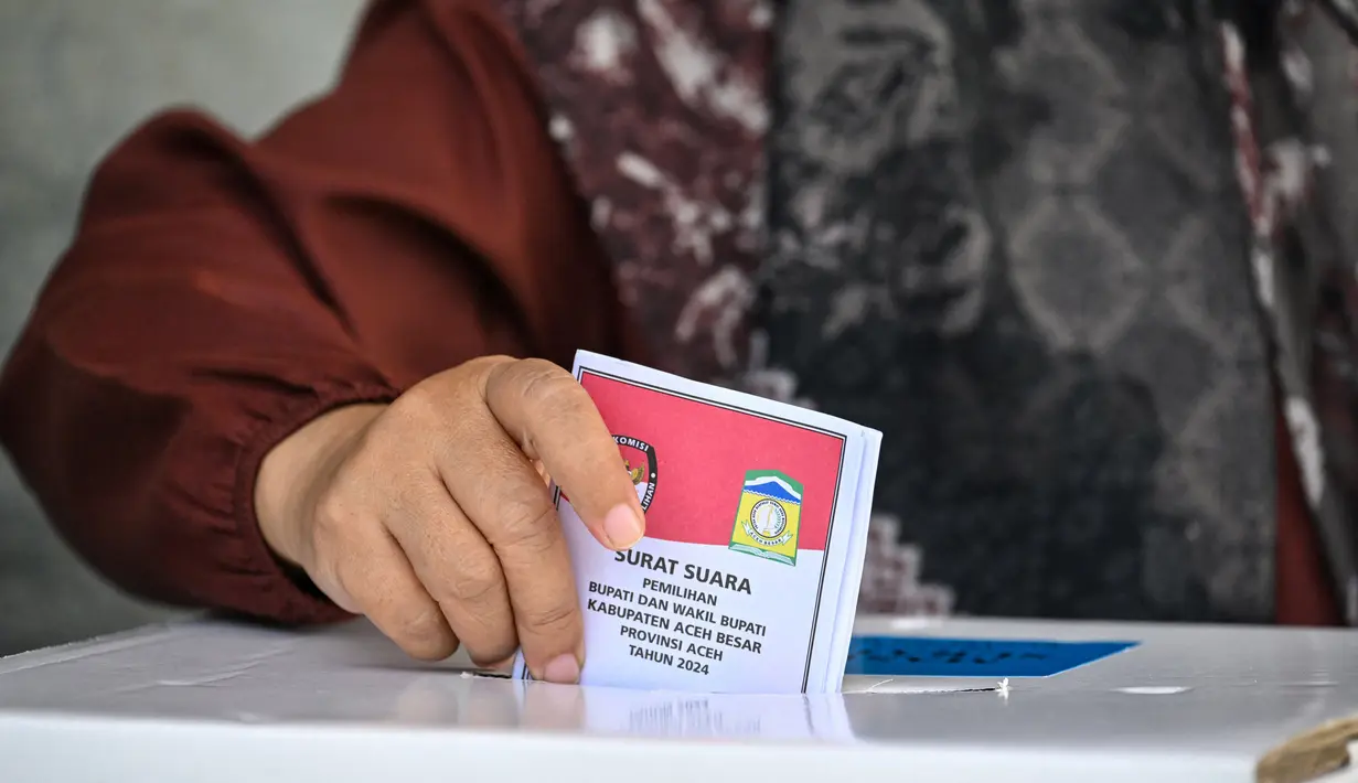 Sejak pertama kali diperkenalkan, Pilkada telah menjadi sarana untuk memilih pemimpin daerah yang diharapkan berkualitas. Tampak dalam foto, pemilih memasukkan surat suaranya dalam pemilihan kepala daerah di Darul Imarah, pinggiran Banda Aceh pada 27 November 2024. (CHAIDEER MAHYUDDIN/AFP)