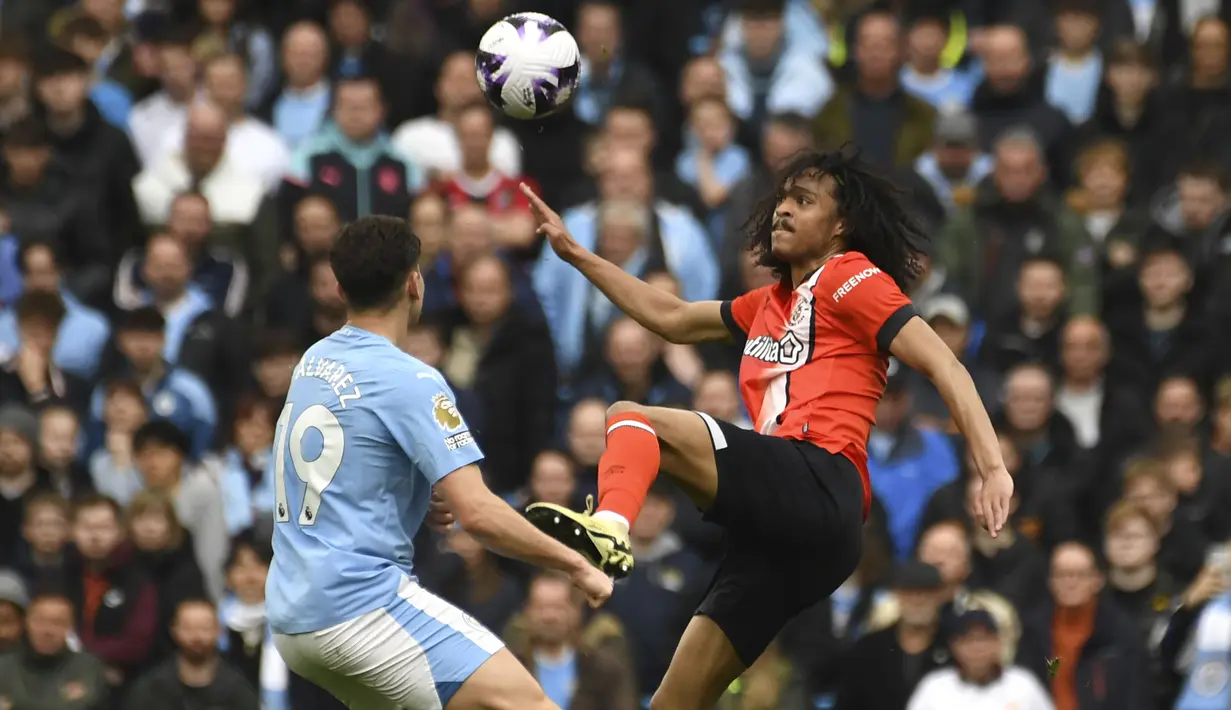 Gelandang Luton Town, Tahith Chong (kanan) berusaha mengontrol bola di depan striker Manchester City, Julian Alvarez pada laga pekan ke-33 Premier League 2023/2024 di Etihad Stadium, Manchester, Sabtu (13/4/2024). (AP Photo/Rui Vieira)