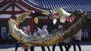 Penduduk memainkan "Kinryu no Mai," atau Tarian Naga Emas di Kuil Sensoji di Tokyo, (18/10/2021). Kebanyakan naga Jepang adalah dewa air yang terkait dengan curah hujan dan badan air, dan biasanya digambarkan sebagai makhluk besar, tak bersayap, ular dengan kaki cakar. (AP Photo/Eugene Hoshiko)