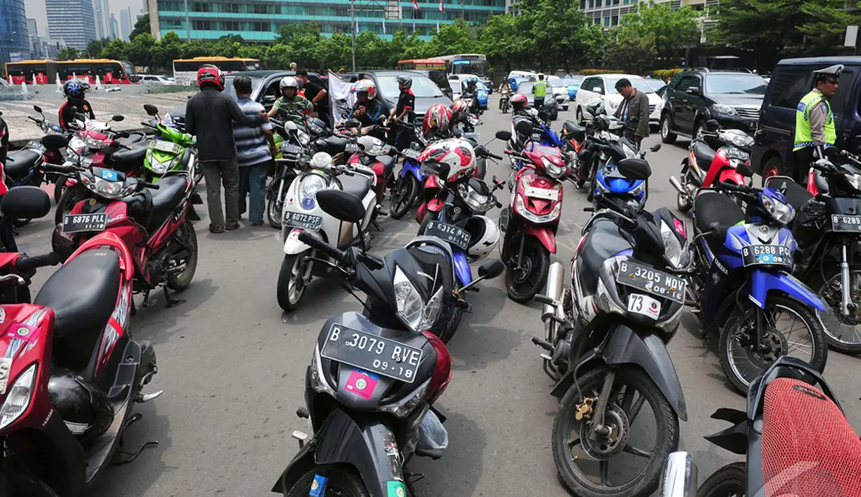 Sejumlah motor sengaja diparkirkan di tengah jalan saat aksi di bundaran HI, Jakarta, Minggu (22/12/2014). (Liputan6.com/Johan Tallo)