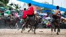 Para joki beradu cepat saat bersaing dalam perlombaan balap kerbau tahunan di Chonburi, Thailand, Selasa (23/10). Lomba ini menandai berakhirnya musim hujan dan awal panen padi dalam tradisi yang berumur lebih dari satu abad. (Jewel SAMAD/AFP)