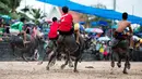 Para joki beradu cepat saat bersaing dalam perlombaan balap kerbau tahunan di Chonburi, Thailand, Selasa (23/10). Lomba ini menandai berakhirnya musim hujan dan awal panen padi dalam tradisi yang berumur lebih dari satu abad. (Jewel SAMAD/AFP)