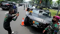 Warga memotret anak di kendaraan taktis TNI yang dipamerkan di depan Istana Merdeka, Jakarta, Senin (4/10/2021). Ratusan alat utama sistem persenjataan (Alutsista) TNI dipamerkan sepanjang pinggir jalan sekeliling kawasan Monas dalam rangka peringatan HUT ke-76 TNI. ​(merdeka.com/Arie Basuki)