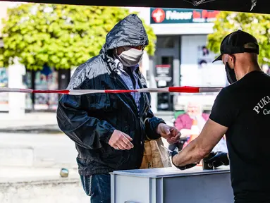 Staf perusahaan katering memberikan makanan gratis kepada pria di Berlin, Jerman (16/4/2020). Tingkat infeksi baru COVID-19 di Jerman terus berada di bawah masa puncak saat jumlah kasus terkonfirmasi bertambah 2.866 dalam satu hari menjadi 130.450. (Xinhua/Binh Truong)