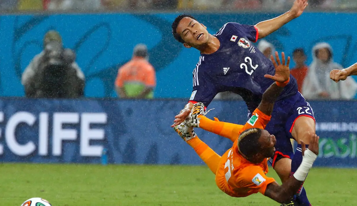 Gelandang Pantai Gading, Geoffroy Serey Die (kiri) terjatuh setelah diganjal Maya Yoshida (Jepang) di laga penyisihan Piala Dunia 2014 Grup C di Pernambuco Arena, Recife, Brasil, (15/6/2014). (REUTERS/Stefano Rellandini)