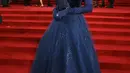 Niomi Smart tampil bak putri raja dengan gaun biru yang gemerlap. Gaun ini memiliki detail atasan beluduru biru navy yang disambung dengan ball gown berkilauan berwarna biru yang senada dengan long gloves yang dikenakannya.