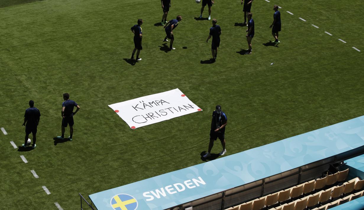 Tim Swedia berpose di sebelah tanda bertuliskan "Get Well Christian" untuk gelandang Denmark Christian Eriksen selama sesi latihan di stadion La Cartuja di Seville, Spanyol, Minggu (13/6/2021). Swedia akan bertanding melawan Spanyol pada Grup E Euro 2020.  (AP Photo/Thanassis Stavrakis)