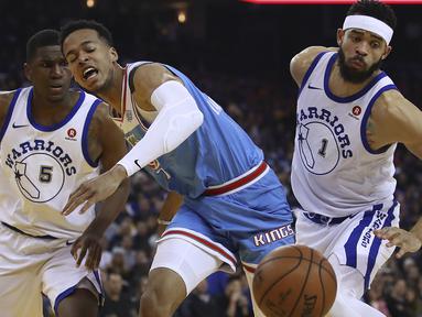 Ekspresi pemain Sacramento Kings, Skal Labissiere (tengah) saat berebut bola dengan dua pemain Warriors  pada laga NBA basketball game di Golden 1 Center, Oakland, California, (16/3/2018). King menang 98-93. (AP/Ben Margot)