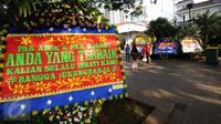Warga berfoto di depan karangan bunga untuk Gubernur DKI Jakarta Basuki Tjahaja Purnama dan Wagub Djarot Sjaiful Hidayat di halaman Balai Kota Jakarta, Selasa (25/4). Karangan bunga ini berisi pernyataan dukungan. (Liputan6.com/Helmi Fithriansyah) 