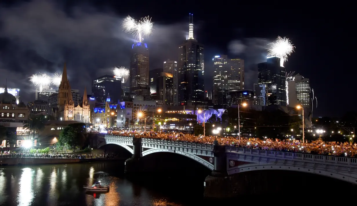 Kembang api menghiasi langit di sepanjang Sungai Yarra pada malam Tahun Baru di Melbourne. (01/1/2018). Langit di kota Sydney juga dihujani sekitar 13 ribu kembang api jenis shell dan 30 ribu kembang api jenis komet. (AFP Photo / Mal Fairclough)