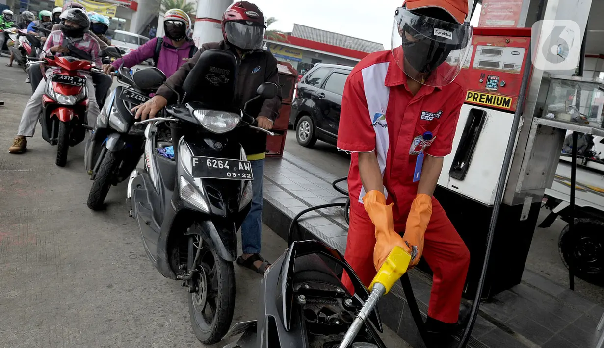 Petugas dengan sarung tangan, masker dan pelindung wajah melayani pembeli BBM di SPBU kawasan Cilendek, Bogor, Selasa (5/5/2020). Mencegah penularan Covid-19, sejumlah perusahaan memberikan pelindung diri kepada pegawai, terlebih yang berhubungan langsung dengan pelanggan. (merdeka.com/Arie Basuki)