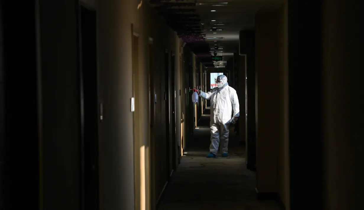 Pekerja berpakaian pelindung menyemprotkan desinfektan pada lorong hotel yang digunakan dalam isolasi medis virus corona di Wuhan, Provinsi Hubei, China, Senin (3/2/2020). Pengungkap virus corona, dr Li Wenliang, meninggal pada 7 Februari 2020 akibat virus corona. (Chinatopix via AP)