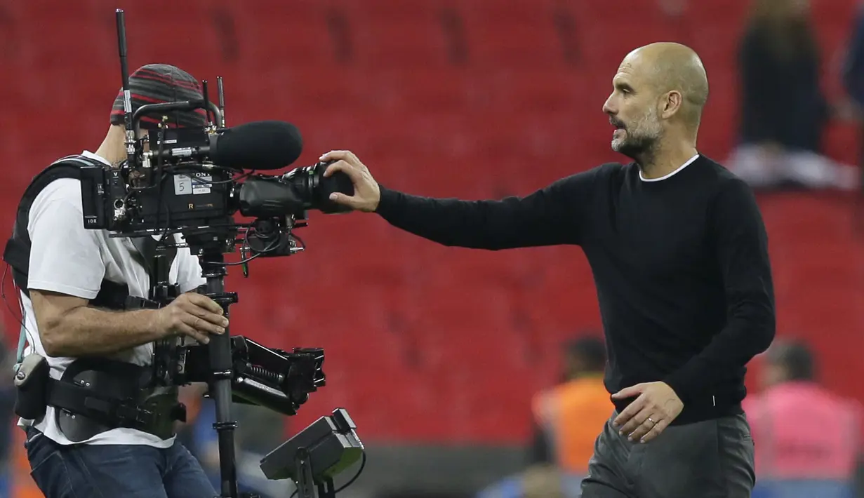 Pelatih Manchester City, Pep Guardiola menutup kamera usai timnya laga melawan Tottenham pada lanjutan Premier League di Wembley Stadium, (14/4/2018). Manchester City menang 3-1. (AP/Tim Ireland)