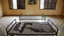 Sebuah foto terpajang di dinding ruangan yang pernah menjadi tempat penyiksaan di bekas penjara Khmer Merah Tuol Sleng, Phnom Penh, (5/8/2014). (REUTERS/Damir Sagolj)