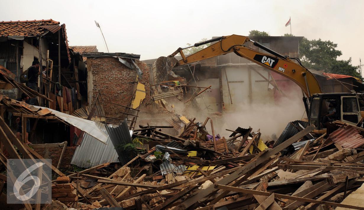 Sebuah eskavator merubuhkan rumah warga di Kampung Pulo, Jakarta, Kamis (20/8/2015). 2200 personil gabungan dari Kepolisian dan satpol PP dikerahkan untuk mengamankan penggusuran warga Kampung Pulo. (Liputan6.com/HelmiFithriansyah)