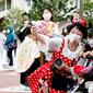Pengunjung mengenakan masker guna melindungi diri dari virus corona berswafoto sebelum memasuki Tokyo Disneyland di Urayasu, dekat Tokyo, Rabu (1/7/2020). Tokyo Disneyland dibuka kembali untuk pertama kalinya dalam empat bulan setelah sempat ditutup karena penyebaran Covid-19. (AP/ Koji Sasahara)