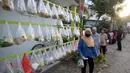 Antrean warga sekitar perumahan Villa Pamulang mengambil paket sembako gratis bernama “Jumat Berkah” yang digantung di Tangerang Selatan, Jumat (28/8/2020). Setiap Jumat selama pandemi, warga perumahan itu mendonasikan sembako untuk warga sekitar yang terdampak COVID-19. (merdeka.com/Dwi Narwoko)