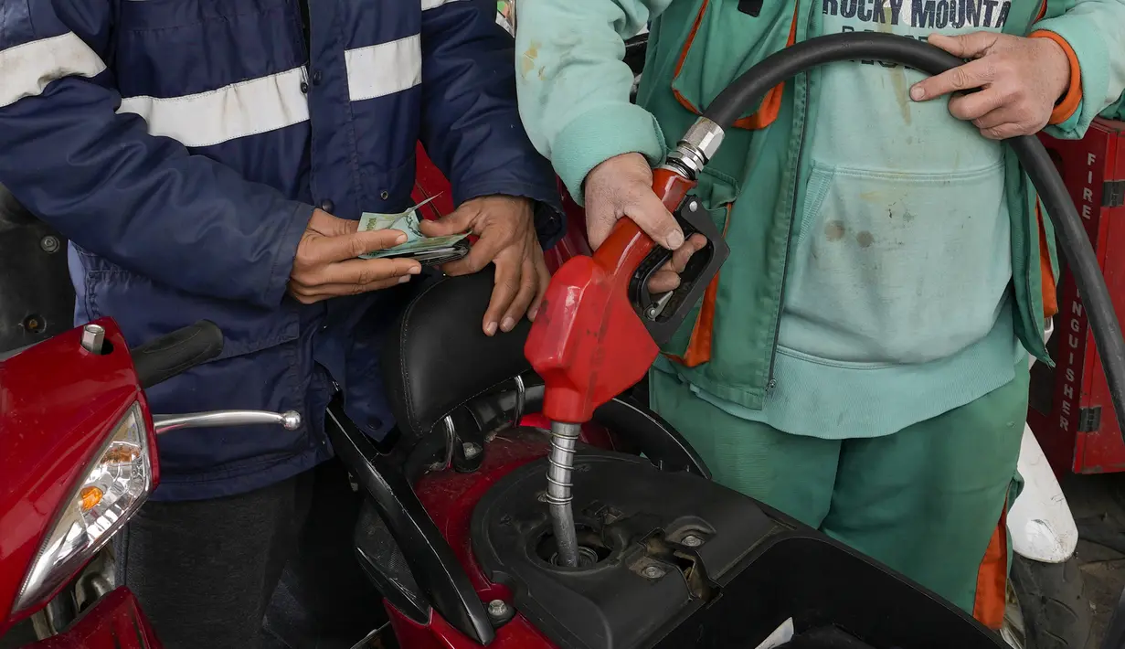 Seorang pengendara motor mendapatkan bahan bakar di sebuah pompa bensin di Beirut, Senin (7/3/2022). Kenaikan harga minyak di seluruh dunia akibat dari invasi Rusia ke Ukraina menyebabkan antrean panjang kendaraan di pompa bensin selama krisis ekonomi terburuk Lebanon. (AP Photo/Hassan Ammar)