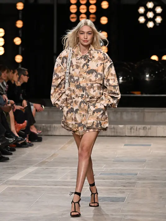 <p>Model AS Gigi Hadid mempersembahkan kreasi untuk peragaan busana Isabel Marant Spring-Summer 2023 pada Paris Womenswear Fashion Week di Paris, Prancis, 29 September 2022. Gigi tampil leggy dalam balutan jaket oversized cameo-print bernuansa militer saat menampilkan busana karya Isabel Marant. (Emmanuel DUNAND/AFP)</p>