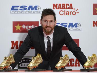 Bintang Barcelona, Lionel Messi melakukan sesi foto dengan Sepatu Emas Eropa pada acara European Golden Shoe awards 2017 di Antigua Fabrica Estrella Damm, Barcelona, (24/11/2017). (AFP/Josep Lago)