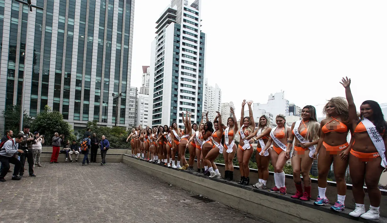 Juru foto mengambil gambar dari belasan wanita seksi yang berpose di Paulista Avenue, Sao Paulo, Senin (8/8). Mengenakan bikini, para wanita tersebut mempromosikan kontes Miss BumBum 2016. (Miguel SCHINCARIOL/AFP)