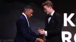 Pemain Juventus Matthijs de Ligt (kanan) meraih piala Kopa Trophy pada malam penghargaan Ballon d'Or 2019 di Chatelet Theatre, Paris, Prancis, Senin (2/12/2019). De Ligt dinobatkan sebagai pemain muda U21 terbaik di dunia. (FRANCK FIFE/AFP)
