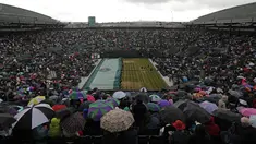 Staf menutup lapangan karena hujan jelang pertandingan perempat final wanita antara Garbine Muguruza Spanyol dan petenis Rusia Svetlana Kuznetsova pada hari kedelapan Kejuaraan Wimbledon 2017, London, (11/7). (AFP Photo/Adrian Dennis)