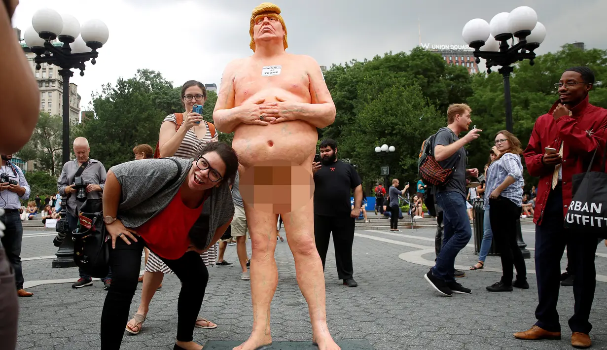 Warga AS foto bersama dengan patung Donald Trump tanpa busana di Union Square Park, New York, AS, Kamis (18/8). Patung Capres AS dari Partai Republik ini juga dipajang di San Francisco, Los Angeles, Cleveland, dan Seattle. (REUTERS/Brendan McDermid)
