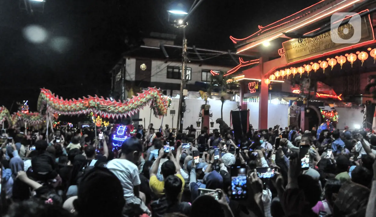 Warga menyaksikan pawai Liong dan Barongsai saat perayaan Cap Go Meh di Jalan Surya Kencana, Bogor, Jawa Barat, Minggu (5/2/2023). Perayaan Cap Go Meh di Bogor dimeriahkan oleh lebih dari 26 tim grup liong barongsai, 30 orang pengerek bendera, tiga tim drum band, 17 tandu dewa-dewi. (merdeka.com/Iqbal S Nugroho)