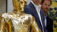 Pangeran William dan Harry melihat C3P0 droid saat mengunjungi studio pembuatan film Star Wars di Pinewood Studios, London, (19/4). Pangeran Inggris itu berkeliling Pinewood untuk mengunjungi workshop produksi film Star Wars (REUTERS/Adrian Dennis/Pool)