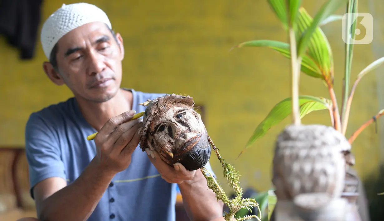 Seniman, Herman Ronda (49) mengukir bibit pohon kelapa yang dijadikan bonsai di Pondok Benda Pamulang, Tangerang Selatan, Selasa (13/10/2020). Budidaya bonsai tanaman kelapa semakin digemari untuk memanfaatkan waktu dengan harga mulai dari Rp 250 ribu hingga Rp 500 ribu. (merdeka.com/Dwi Narwoko)