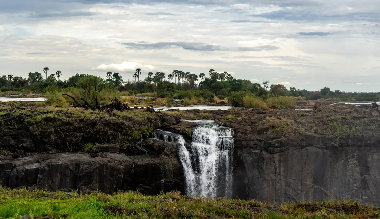 Sebuah foto Air Terjun Victoria, sebuah situs warisan dunia UNESCO berukuran tinggi 108 meter dan lebar hampir 2 km telah mencatat tingkat terendah akibat kekeringan parah di Air Terjun Victoria, di Zimbabwe (13/11/2019). (AFP/Zinyange Auntony)