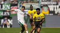 Bek Borussia Dortmund, Ian Maatsen, mengawal pemain Borussia Monchengladbach, Stefan Lainer, dalam laga Bundesliga di Borussia Park, Sabtu (13/4/2024) (AP Photo/Martin Meissner)