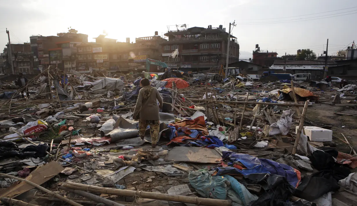 Warga mencari barang yang masih bisa terpakai di tempat pengungsian korban gempa bumi di Chuchepati, Kathmandu, Nepal, Selasa (14/3). Pemerintah Nepal terpaksa menggusur kamp ini karena dianggap sudah terlalu lama. (AP Photo)