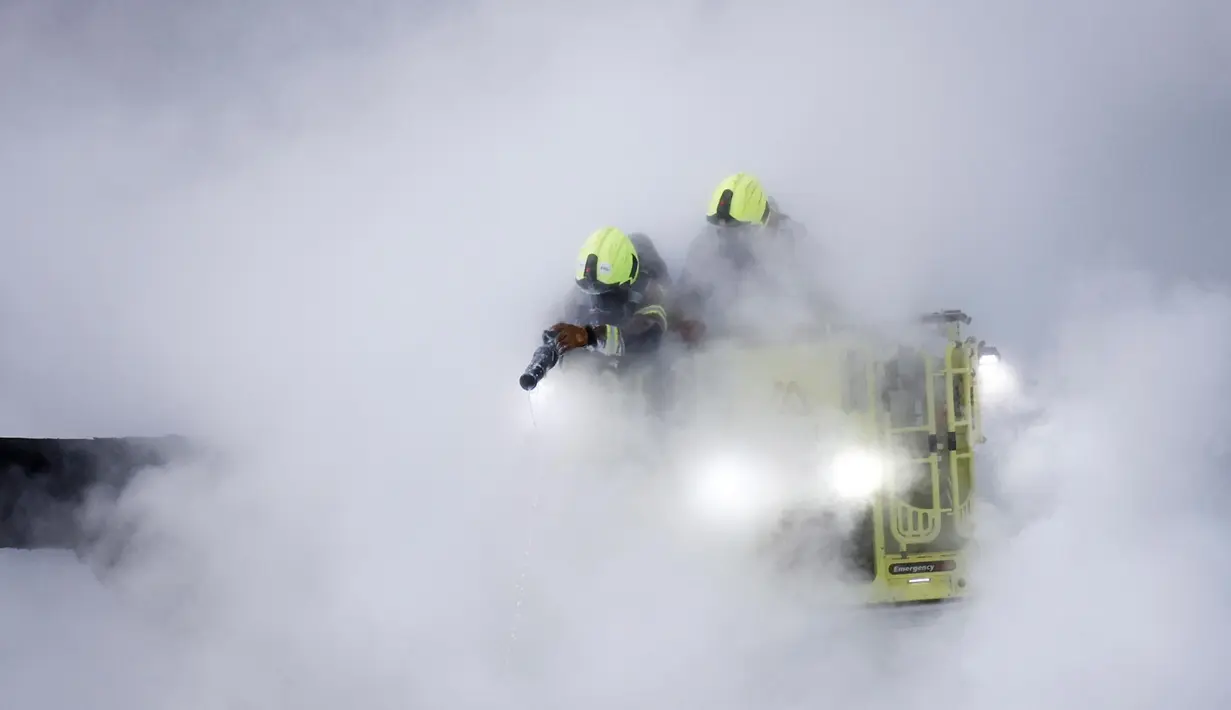 Petugas pemadam berupaya memadamkan sisa api dari kebakaran yang terjadi di gardu induk yang memasok listrik ke Bandara Heathrow, Hayes, London, Inggris pada 21 Maret 2025. (BENJAMIN CREMEL/AFP)