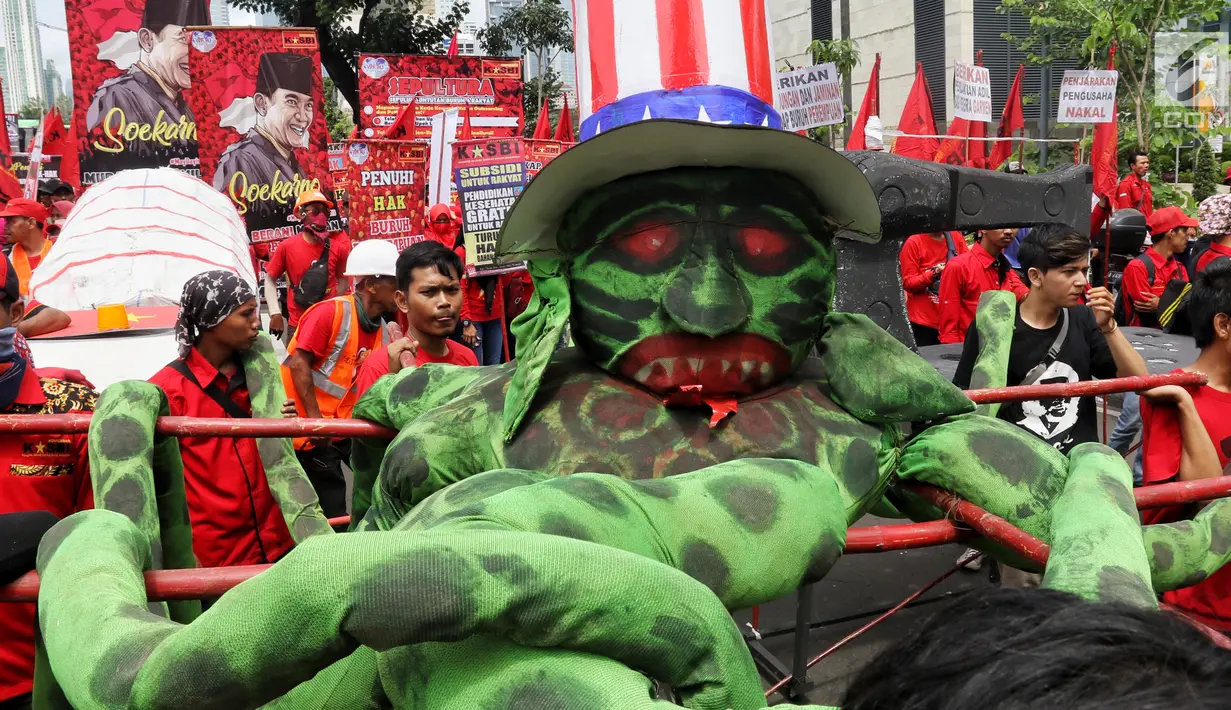 Peserta aksi dari sejumlah elemen buruh mengusung boneka gurita raksasa dalam peringatan Hari Buruh Sedunia di kawasan Bundaran HI, Jakarta, Rabu (1/5/2019). Massa aksi dalam peringatan Hari Buruh 2019 tidak dapat mendekati Istana Merdeka lantaran tertahan di kawasan itu. (Liputan6.com/Johan Tallo)