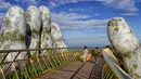 Pengunjung berjalan di sepanjang Golden Bridge di Perbukitan Ba Na dekat Danang, Vietnam, Selasa (31/7). Keunikan Golden Bridge telah menarik perhatian wisatawan berbagai belahan dunia. (Linh PHAM/AFP)