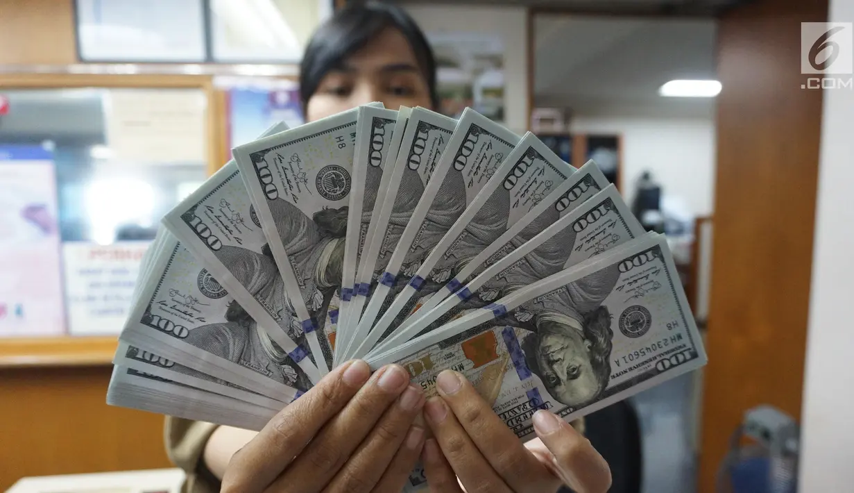 Teller menunjukkan mata uang dolar AS di penukaran uang di Jakarta, Rabu (10/7/2019). Nilai tukar rupiah terhadap dolar Amerika Serikat (AS) ditutup stagnan di perdagangan pasar spot hari ini di angka Rp 14.125. (Liputan6.com/Angga Yuniar)