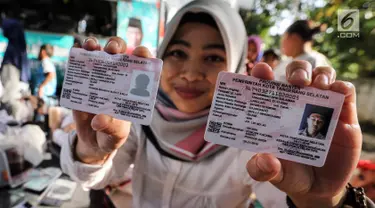 Petugas Disdukcapil menunjukkan dua Kartu Identitas Anak (KIA) untuk balita dan anak di atas lima tahun di Pondok Aren, Tangerang Selatan, Jumat (16/11). Pemkot menargetkan 2019 mendatang layanan penerbitan KIA sudah rampung. (Liputan6.com/Fery Pradolo)