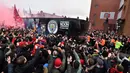 Pendukung Liverpool menyambut kedatangan pemain Manchester City saat tiba jelang pertandingan Liga Champions di stadion Anfield di Liverpool (4/4). (AFP Photo/Anthony Devlin)
